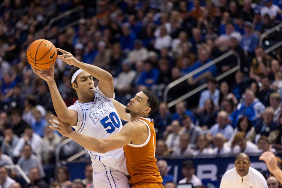 BYU center Aly Khalifa (50) passes the ball while blocked by Texas forward Dylan Disu (1) during their game on Saturday, Jan. 27, 2024.