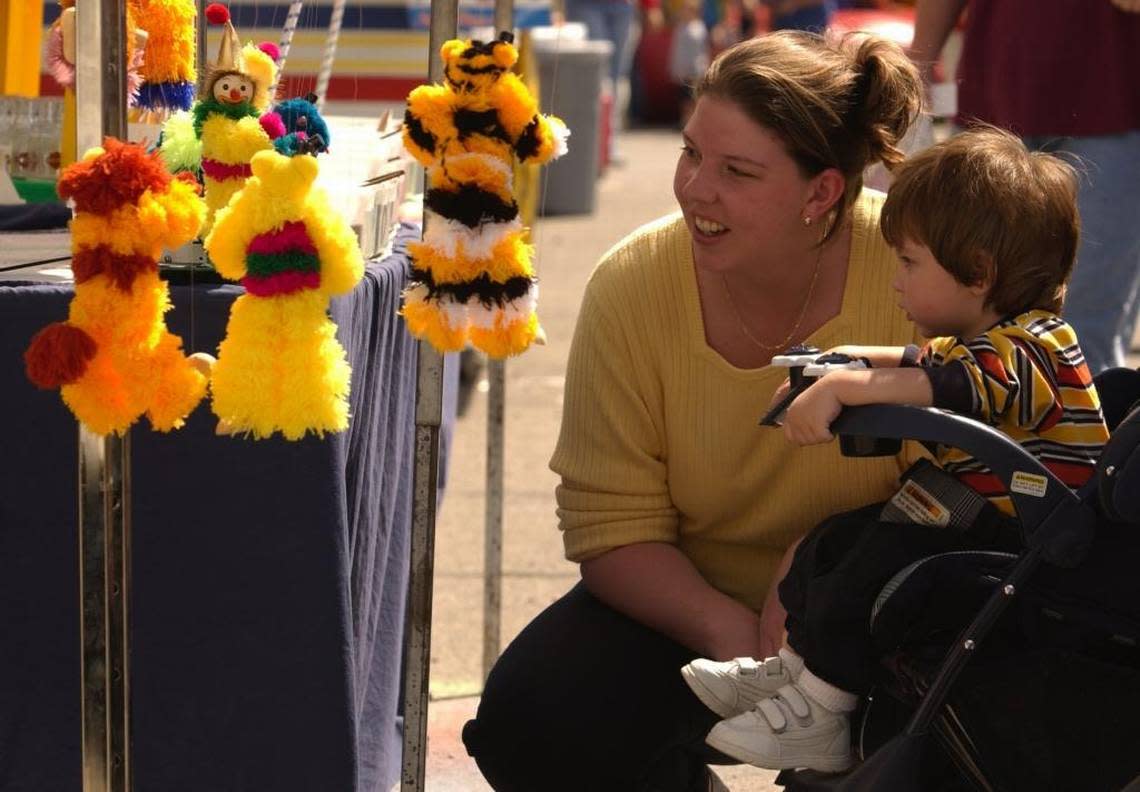 Julie Wilsher of Midway and her son Corey looked at dancing dolls at the 2001 Midway Fall Festival. This year’s festival is Sept. 17 and 18.