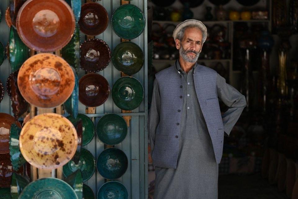 An Afghan vendor waits for customers at his shop selling clay bowls at a market in Istalif district in northwest of Kabul province on July 3, 2023
