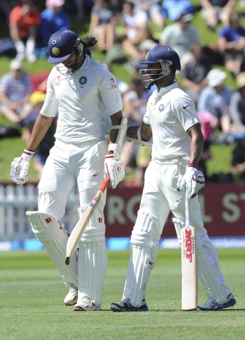 India’s Ishant Sharma, left, receives a reassuring pat from India’s Shikar Dhawan as he departs out for 26 off the bowling of New Zealand’s Trent Boult on the second day of the second cricket test in Wellington, New Zealand, Saturday, Feb. 15, 2014. (AP Photo/SNPA, Ross Setford) NEW ZEALAND OUT