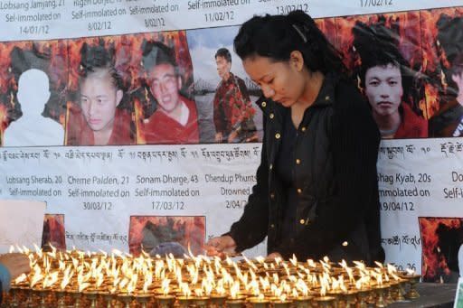 An exile Tibetan woman lights candles at the Tsuglakhang temple in Dharamshala as she mourns the deaths of six Tibetans who self-immolated in protest against Chinese rule