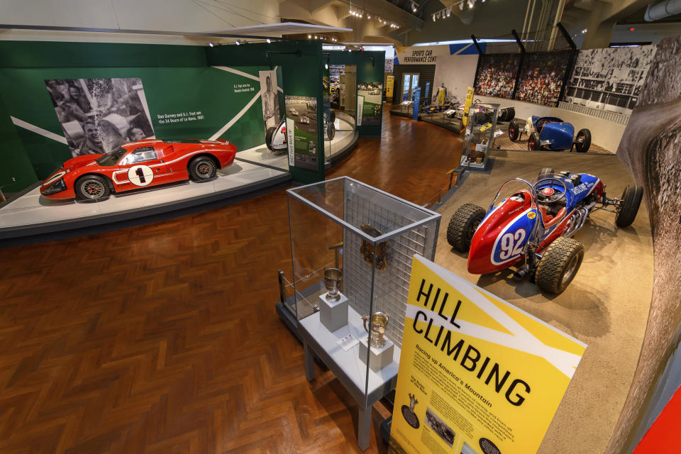 In this image provided by the The Henry Ford, various types of racing cars, including the 1967 Ford Mark IV Race Car, left, are on display as part of the Driven To Win exhibit at the The Henry Ford Museum in Dearborn, Mich. (Wes Duenkel/The Henry Ford via AP)