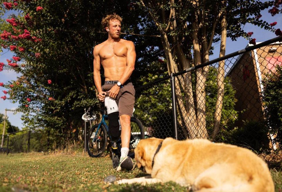 Carson Clough gets ready for a run while his service dog, Calder, keeps him company as he trains for the Paralympics triathlon at Alexander Graham Middle School in Charlotte, N.C., on Saturday, July 6, 2024.