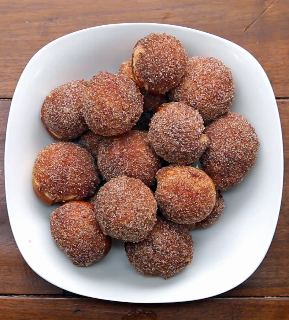 Brown, round cinnamon pretzel bites in a white bowl