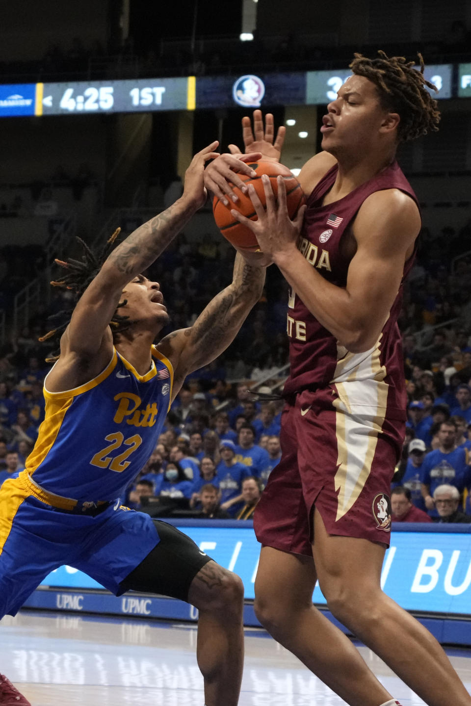 Pittsburgh guard Nike Sibande (22) is fouled by Florida State forward Cam Corhen during the first half of an NCAA college basketball game in Pittsburgh, Saturday, Jan. 21, 2023. Florida State won 71-64. (AP Photo/Gene J. Puskar)