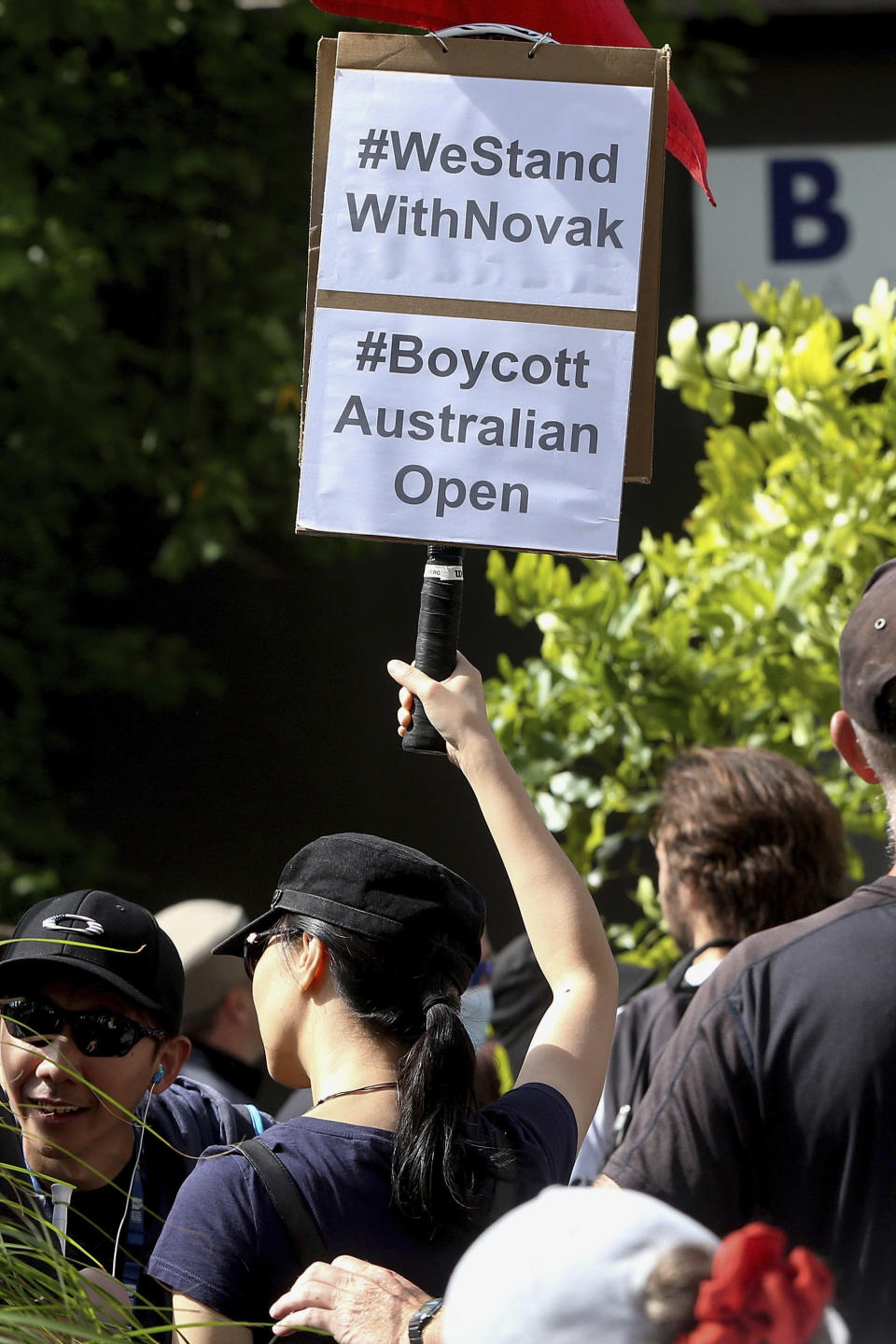 A protester shows a sign supporting Serbia's Novak Djokovic outside the Park Hotel, used as an immigration detention hotel in Melbourne, Australia, Saturday, Jan. 8, 2022. Djokovic has been confined to the detention hotel in Melbourne pending a court hearing on Monday, a week before the start of the Australian Open. He was barred from entering the country late Wednesday when federal border authorities at the Melbourne airport rejected his medical exemption to Australia's strict COVID-19 vaccination requirements. (AP Photo/Hamish Blair)