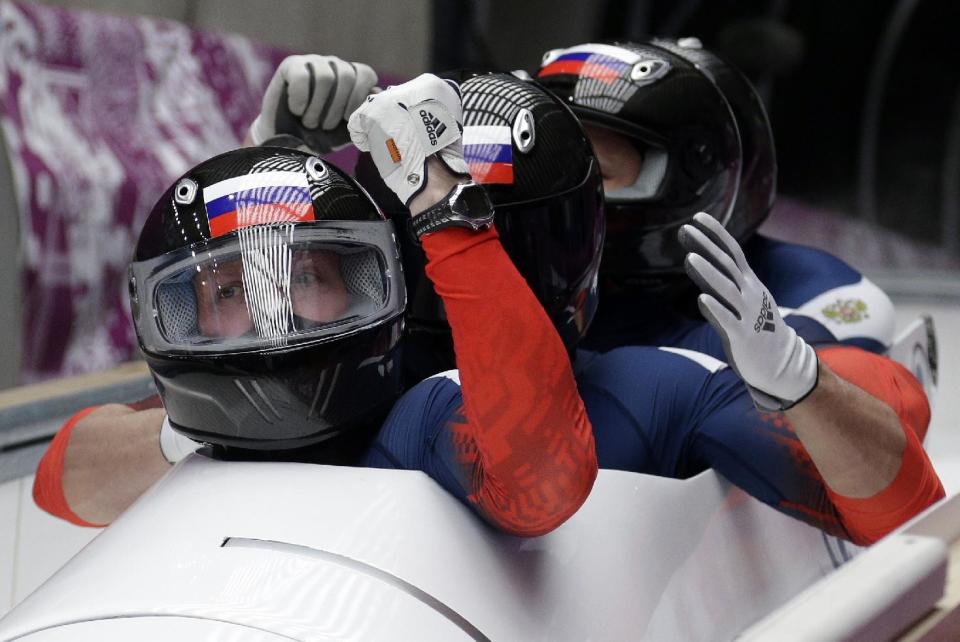 The team from Russia RUS-1, with Alexander Zubkov, Alexey Negodaylo, Dmitry Trunenkov, and Alexey Voevoda, brake in the finish area after tenor second run during the men's four-man bobsled competition at the 2014 Winter Olympics, Saturday, Feb. 22, 2014, in Krasnaya Polyana, Russia. (AP Photo/Michael Sohn)