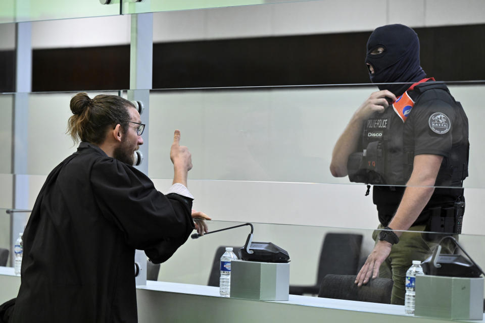 Lawyer Nicolas Cohen, left, speaks with a police officer prior to the reading of the sentences during the trial regarding the attacks at a Brussels metro station and the city's airport at the Justitia building in Brussels, Friday, Sept. 15, 2023. The morning rush hour attacks at Belgium's main airport and on the central commuter line took place on March 22, 2016, which killed 32 people, and nearly 900 others were wounded or suffered mental trauma. (John Thys, Pool Photo via AP)