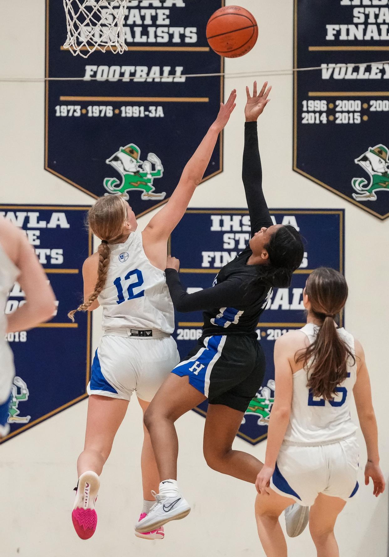 Bishop Chatard Trojans Olivia Berzai (12) attempts to block Heritage Christian guard Mya Davis (3) on Thursday, Jan. 11, 2024, during the City Tournament semifinals at Cathedral High School in Indianapolis. The Bishop Chatard Trojans defeated Heritage Christian, 56-45.