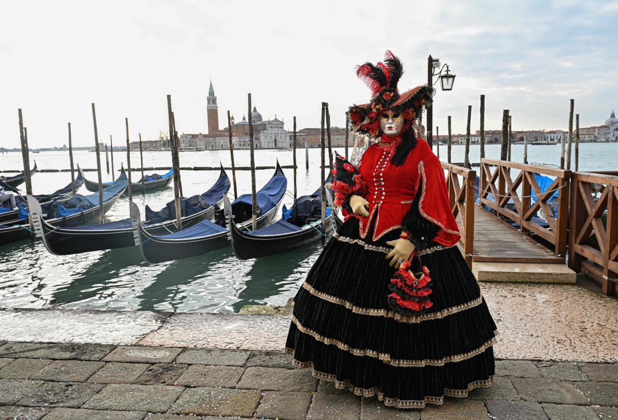 Feb. 20, 2022 : A masked reveler wearing a traditional carnival costume poses on St Mark Square, Venice during the annual carnival.