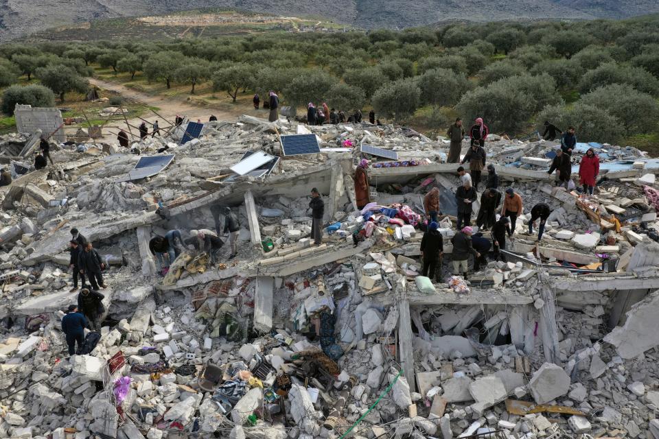 Civil-defense workers and residents search through the rubble of collapsed buildings in the town of Harem near the Turkish border in Idlib province, Syria, Monday, February 6, 2023.