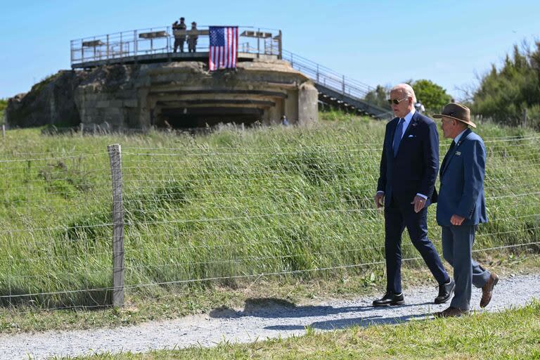 El presidente estadounidense Joe Biden y el superintendente del cementerio estadounidense de Colleville-sur-Mer, Scott Desjardins pasan junto a un búnker alemán de la época de la Segunda Guerra Mundial y una antigua instalación de armas costera en lo alto del acantilado 