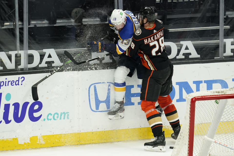 St. Louis Blues left wing Kyle Clifford (13) is checked by Anaheim Ducks defenseman Jani Hakanpaa (28) during the third period of an NHL hockey game Sunday, Jan. 31, 2021, in Anaheim, Calif. (AP Photo/Ashley Landis)