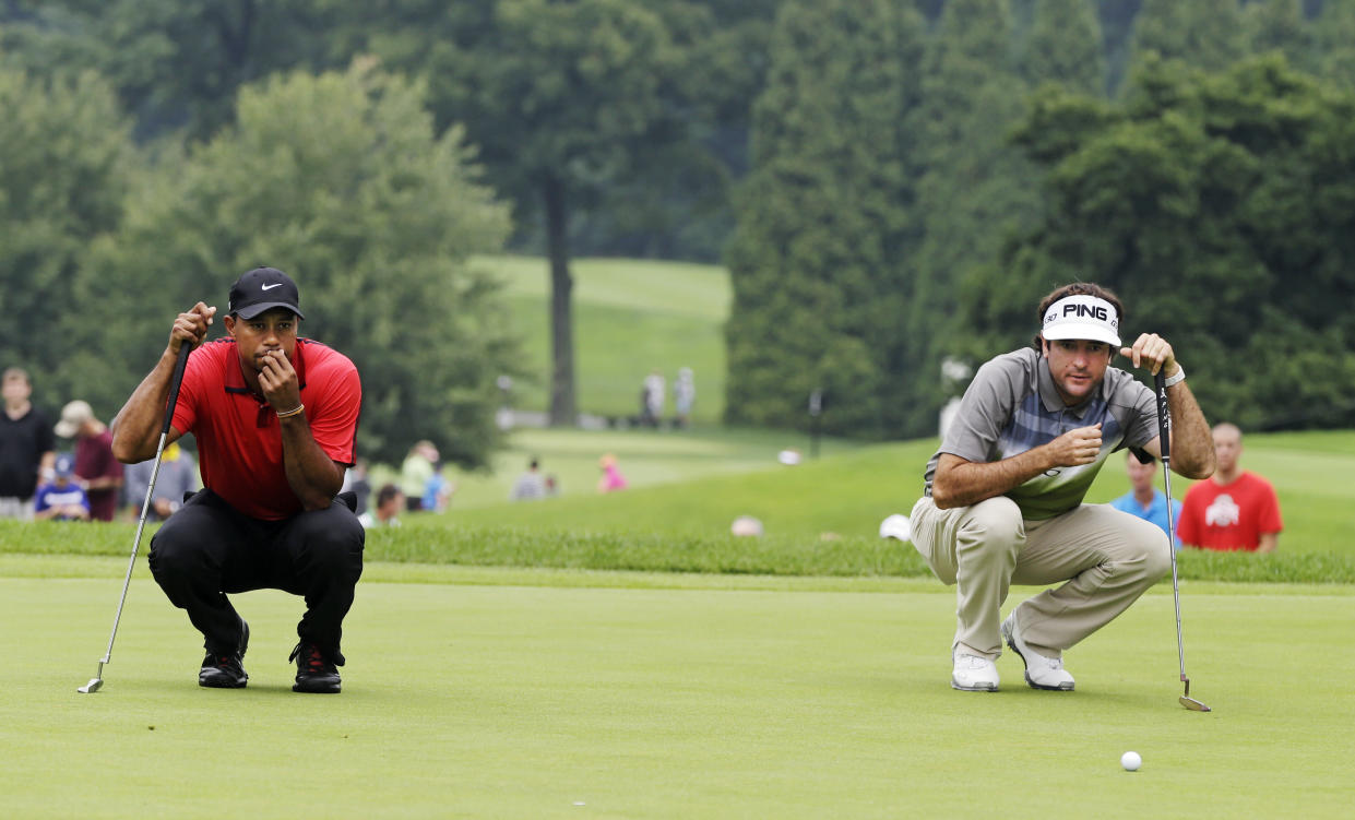 Tiger Woods, left, and Bubba Watson looks over their putts on the second hole during the final round of the Bridgestone Invitational golf tournament Sunday, Aug. 3, 2014, at Firestone Country Club in Akron, Ohio. (AP Photo/Mark Duncan)