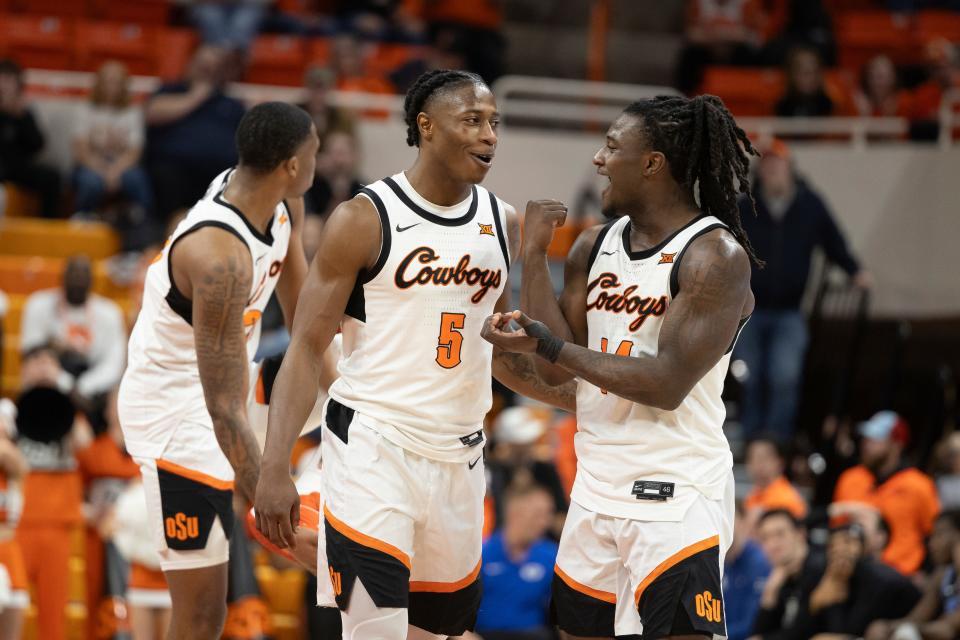 Oklahoma State guard Quion Williams (5) and guard Jamyron Keller (14) celebrate on the court in the second half of the NCAA college basketball game against BYU, Saturday, Feb. 17, 2024, in Stillwater, Okla. (AP Photo/Mitch Alcala)