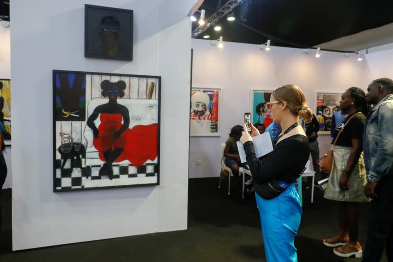 Visitors look at artworks during the Art X in Lagos