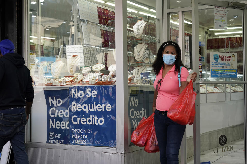 A woman walks out of the Gold City of St. Nicholas jewelry store, in New York, Friday, Sept. 25, 2020. (AP Photo/Mark Lennihan)