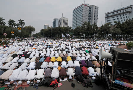 Members of hardline Muslim hold a mass pray as they attend a protest against Jakarta's incumbent governor Basuki Tjahaja Purnama. REUTERS/Beawiharta