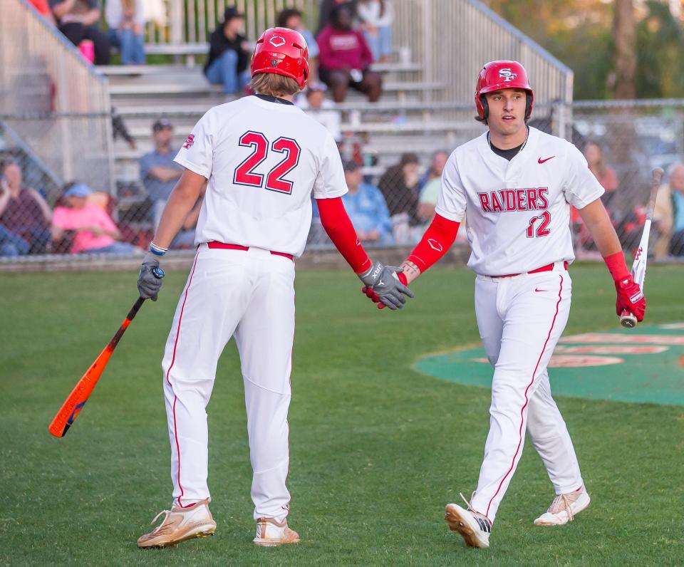 Santa Fe Raiders Caleb Kietzman (22) congratulates Santa Fe Raiders Dylan Lovelace (12) after scoring the fifth run of the game in the first inning. The Santa Fe Raiders hosted the Dunnellon Tigers at Santa Fe High School in Alachua, FL on Friday, March 29, 2024. Forest won after six innings 15-4 after the mercy rule. [Doug Engle/Ocala Star Banner]
