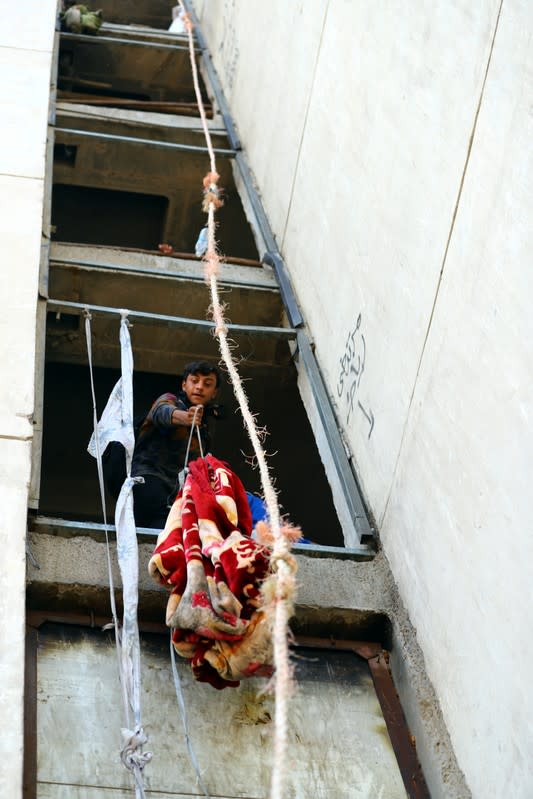 Iraqi demonstrators use blanket to supply food for their fellows inside the high-rise building, called by Iraqi the Turkish Restaurant Building, during anti-government protests in Baghdad