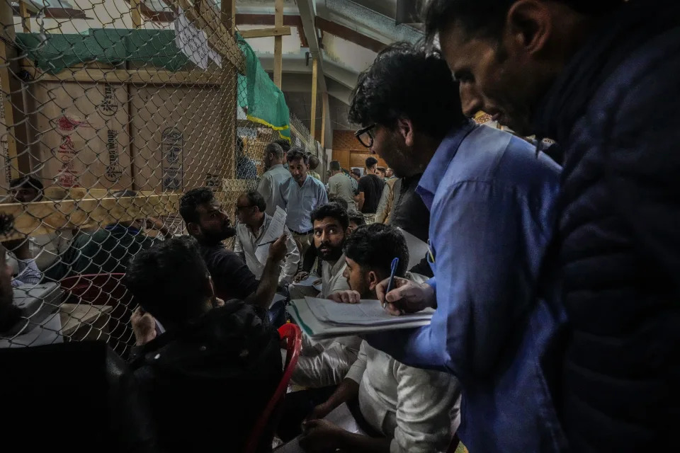 Political party representatives watch as polling officials count the votes in the recent election for a local government in Indian-controlled Kashmir on the outskirts of Srinagar, Tuesday, Oct. 8, 2024. (AP Photo/Mukhtar Khan)