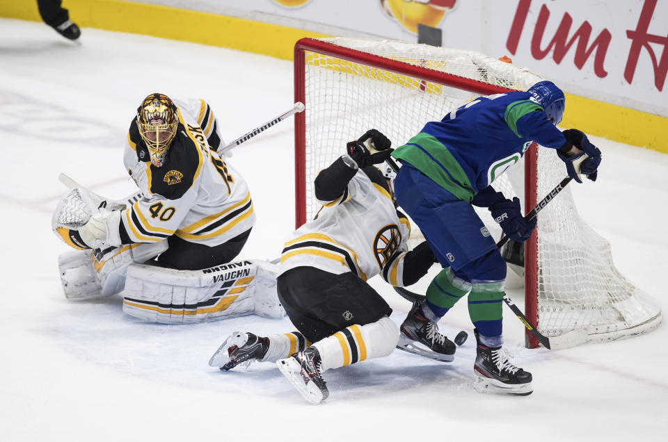 Vancouver Canucks' Loui Eriksson, right, of Sweden, scores a goal as Boston Bruins goalie Tuukka Rask (40), of Finland, watches and Matt Grzelcyk defends during the second period of an NHL hockey game Saturday, Feb. 22, 2020, in Vancouver, British Columbia. (Darryl Dyck/The Canadian Press via AP)