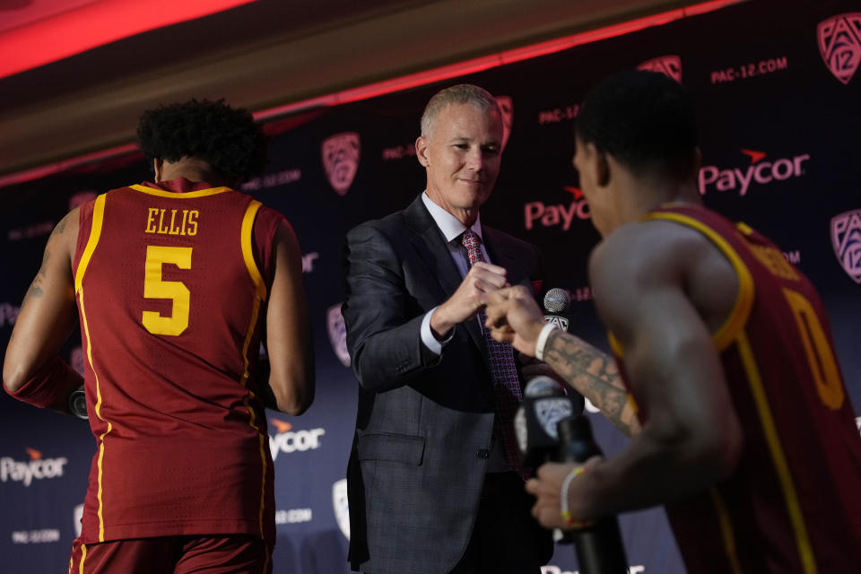 Southern California head coach Andy Enfield, center, greets Kobe Johnson during a news conference at the Pac-12 Conference NCAA college basketball media day Wednesday, Oct. 11, 2023, in Las Vegas. (AP Photo/John Locher)