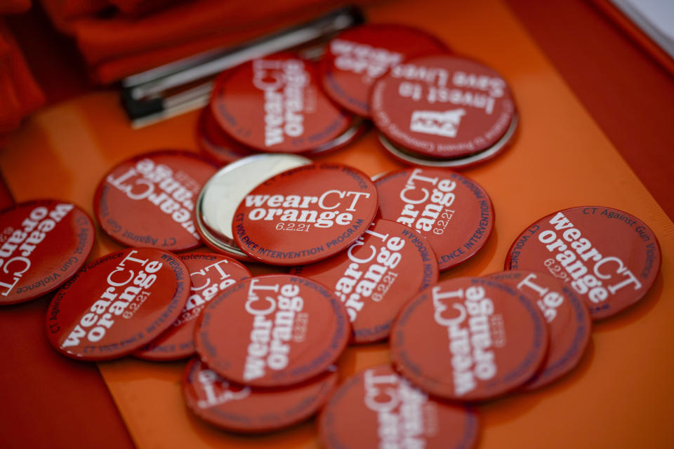 Buttons lay on a table during a rally against gun violence on Friday, June 7, 2024, in Newtown, Conn. (AP Photo/Bryan Woolston)