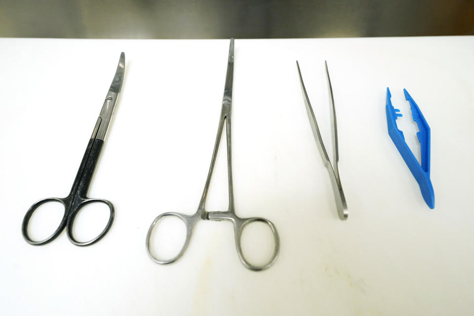 A variety of forceps and tweezers are arranged on a board in one of the four autopsy bays at the Mississippi Crime Laboratory in Pearl, Miss., Aug. 26, 2021. (AP Photo/Rogelio V. Solis)