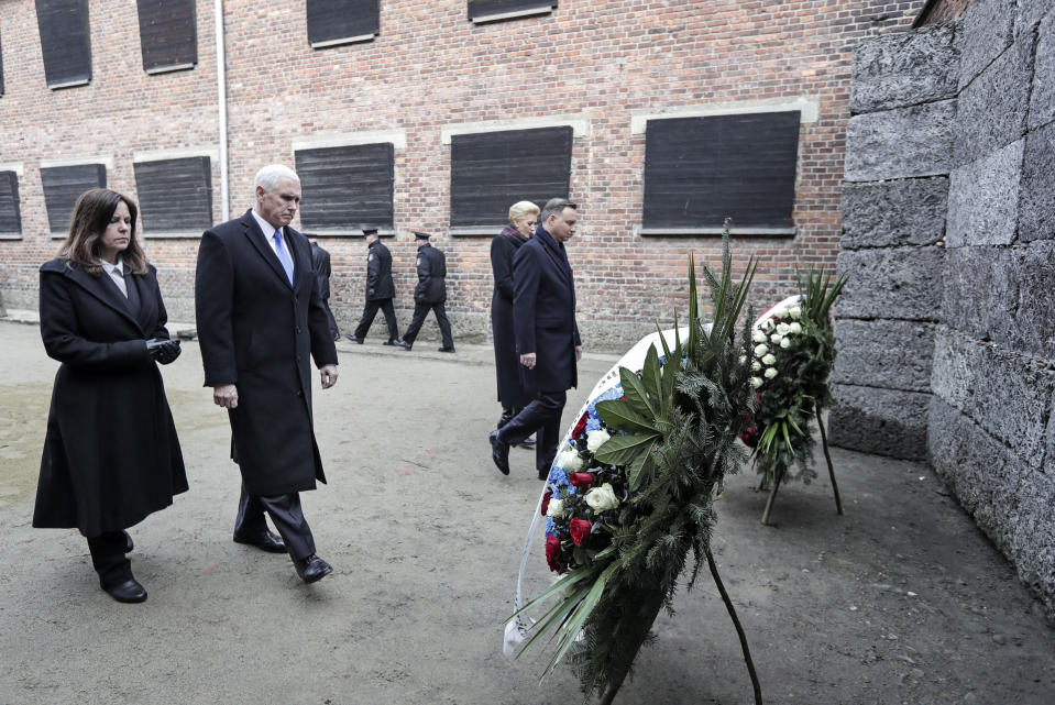 United States Vice President Mike Pence and his wife Karen Pence, left, walk with Poland's President Andrzej Duda and his wife Agata Kornhauser-Duda, right, to wreaths at a death wall during their visit at the Nazi concentration camp Auschwitz-Birkenau in Oswiecim, Poland, Friday, Feb. 15, 2019. (AP Photo/Michael Sohn)