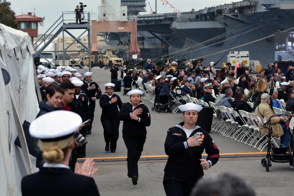 Ship's crew members of USS John L. Canley man the ship