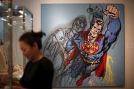 FILE PHOTO: A woman stands in front of Andy Warhol's "Superman", which is expected to fetch USD $6-8 million at a pre-auction viewing at Sotheby's in Los Angeles