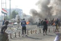 Iraqi demonstrators are seen as they clash with Iraqi security forces during ongoing anti-government protests,in Nassiriya