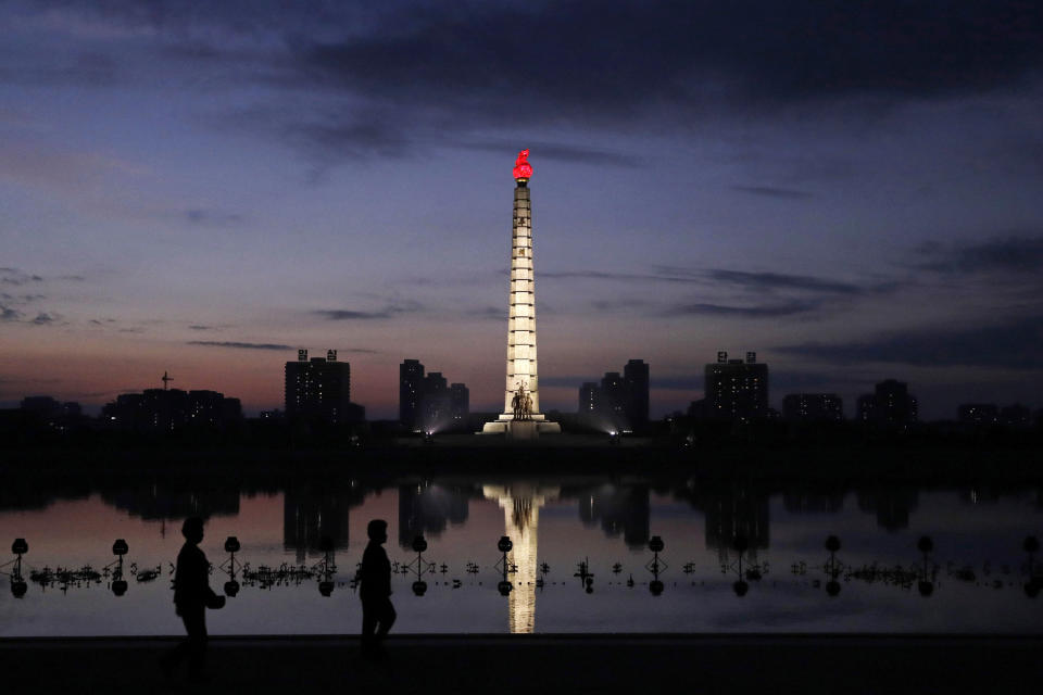 In this Sept. 15, 2018, photo, North Koreans take a walk at dawn by the Tower of Juche Idea in Pyongyang, North Korea. The word Juche is splashed across countless propaganda signs in North Korea and featured in hundreds of state media reports, and while it’s technically a political ideology, it can seem more like a religion because of its difficulty for many outsiders to grasp and ability to inspire devotion among North Koreans. (AP Photo/Kin Cheung)