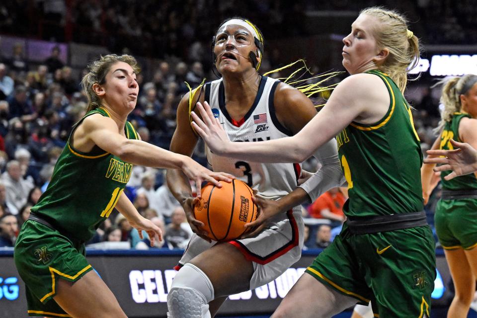 UConn's Aaliyah Edwards (3) drives between Vermont's Bella Vito, left, and Maria Myklebust, right, in the second half of a first-round college basketball game in the NCAA Tournament, Saturday, March 18, 2023, in Storrs, Conn.