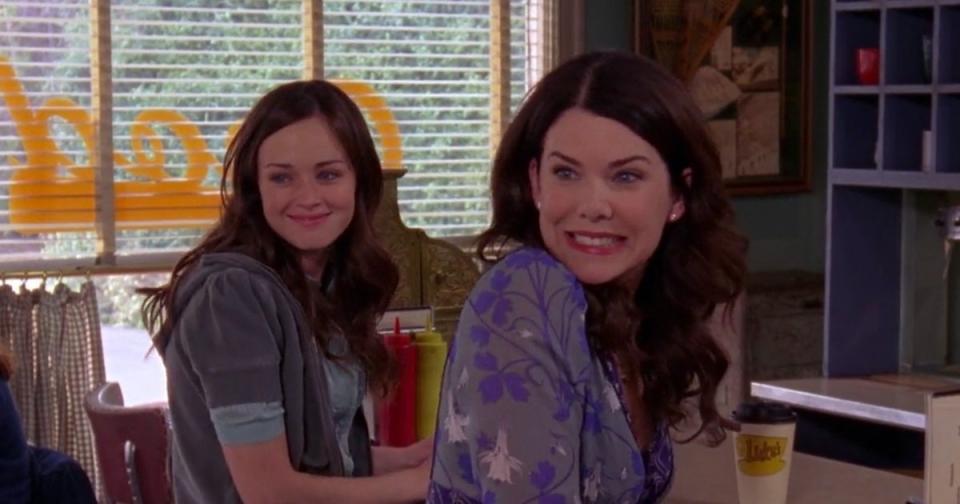 the Gilmore girls smiling and sitting next to each other