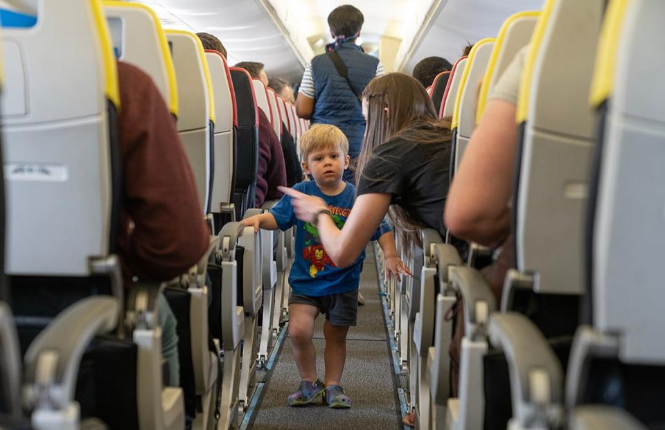 Amy Walker of Eagle Mountain, Utah, instructs her son Dawson, 2, to take his seat during a mock plane event. Breeze Airways hosted an exercise for people with autism, ages 3-20, to experience the process of airplane procedures to make future travel easier.