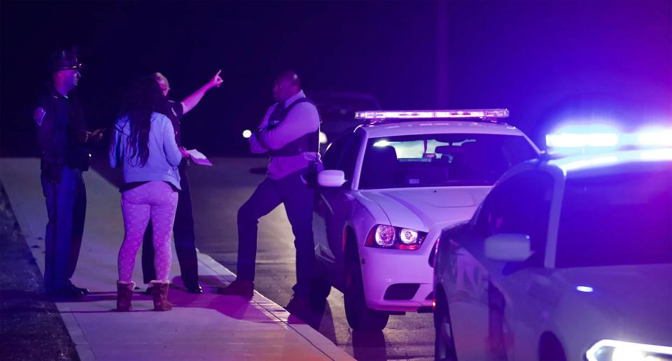 A woman speaks to officers near the FedEx hub following a shooting in Indianapolis,AP