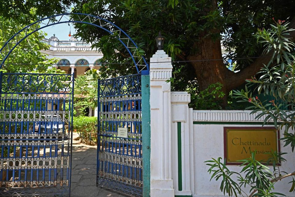 A blue gate opens up to the courtyard of the Chettinadu Mansion in 2021.