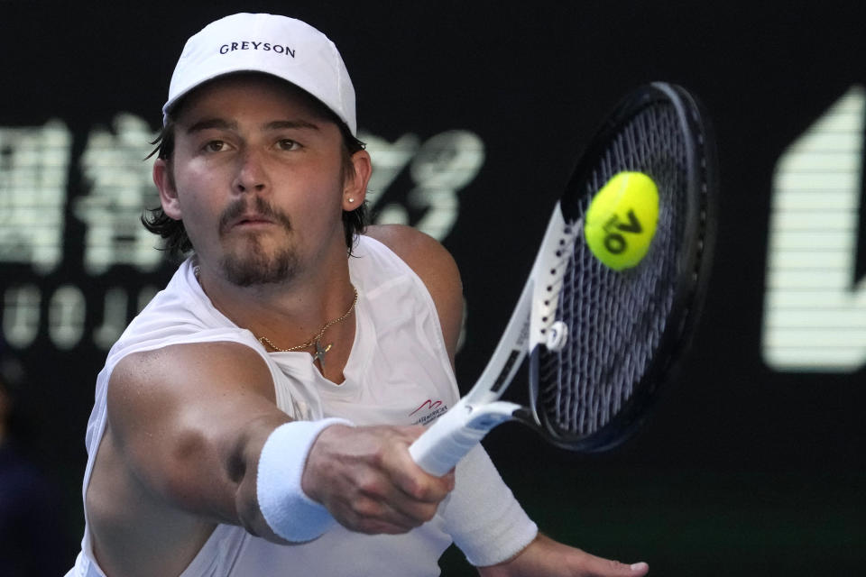 J.J. Wolf of the U.S. plays a backhand return to compatriot Ben Shelton during their fourth round match at the Australian Open tennis championship in Melbourne, Australia, Monday, Jan. 23, 2023. (AP Photo/Ng Han Guan)