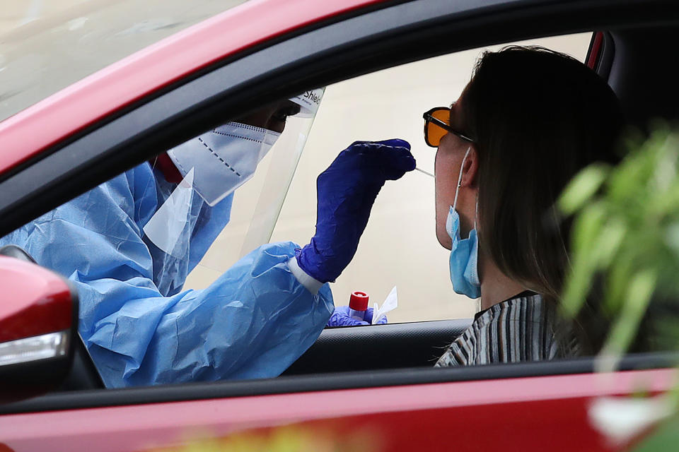 Local residents line up at a drive-in testing center in Brisbane, Friday, December 31, 2021. Omicron continues to be the dominant strain of the virus, accounting for almost 80 per cent of the state's identified cases