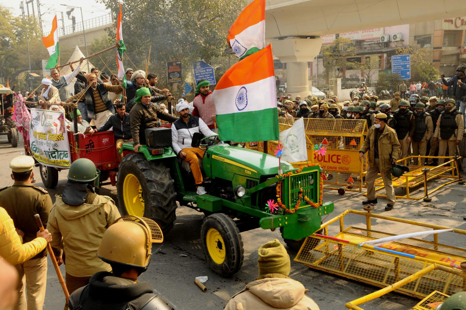 NEW DELHI, INDIA - JANUARY 26 : Indian Farmers attempt to break a barricade farmers who marched to the capital during India's Republic Day celebrations in New Delhi on India January 26, 2021, The thousands of farmers drove a convoy of tractors into the Indian capital as the nation celebrated Republic Day on Tuesday in the backdrop of agricultural protests that have grown into a rebellion and rattled the government. (Photo by Imtiyaz Khan/Anadolu Agency via Getty Images)