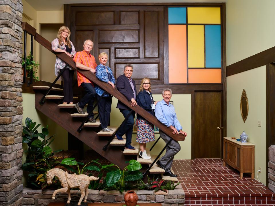 The 'Brady Bunch' actors recreate their iconic pose on the famous Brady house staircase. (Photo: HGTV)