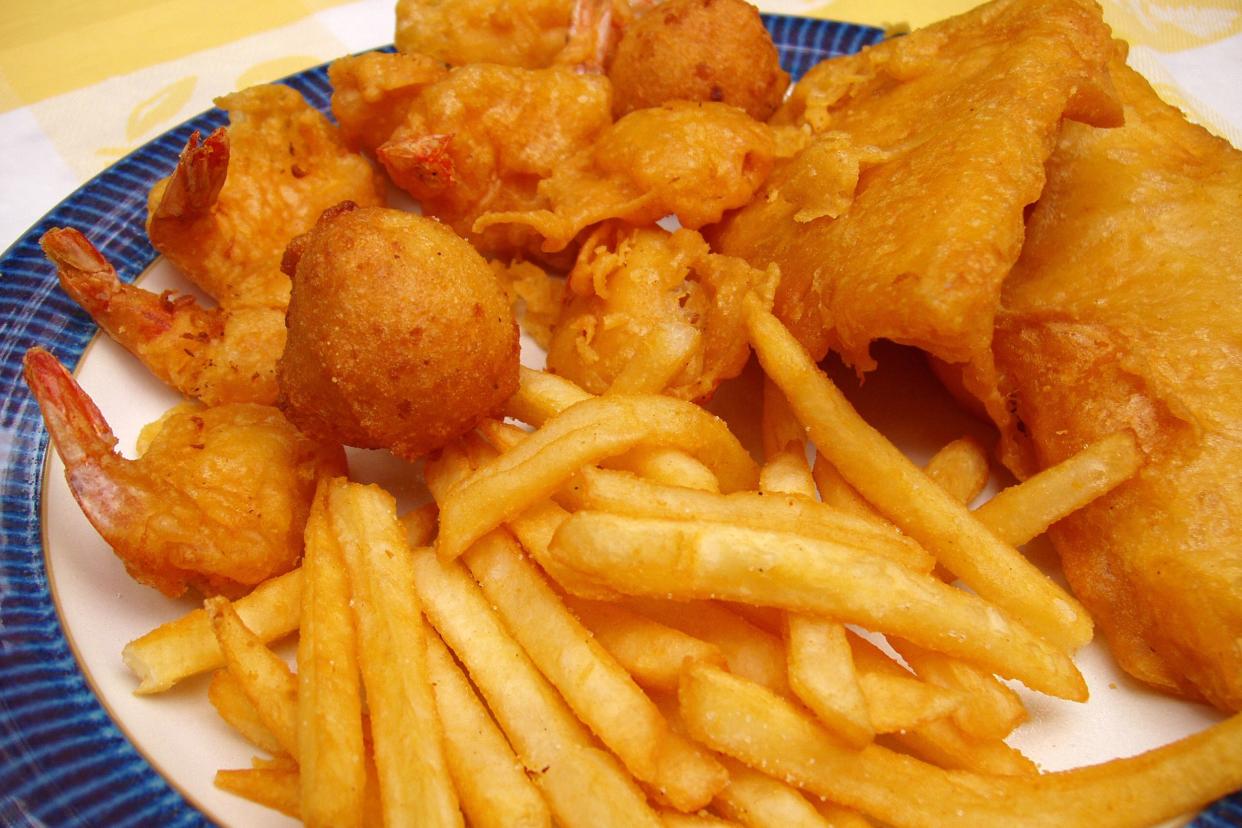 Plate of fried fish, hush puppies, and french fries