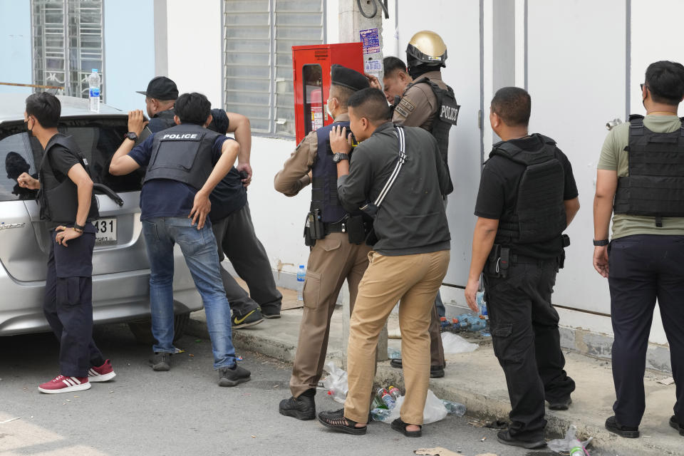 A group police are seen outside the home of a senior police officer in Bangkok, Thailand, Wednesday, March 15, 2023. Thai police have arrested a fellow officer who fired multiple gunshots from his home in Bangkok which forced an over 24 hours-long standoff after his colleagues tried to take him to be treated for mental illness. (AP Photo/Sakchai Lalit)