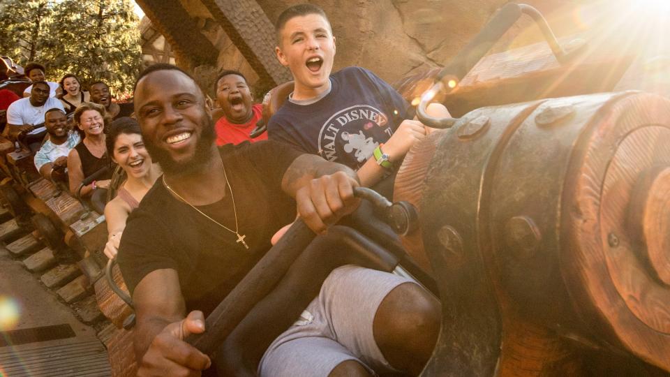  People on a roller coaster smiling. 