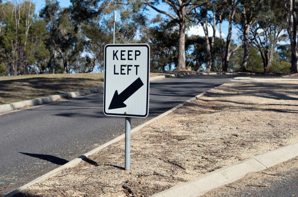 Photo of a "keep left" sign on the road.