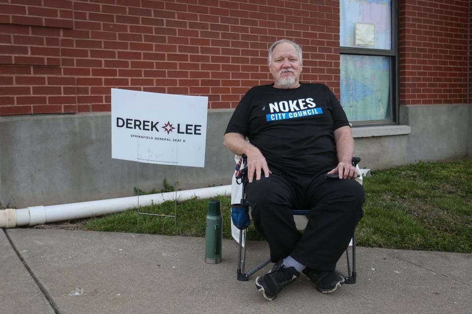 Electioneer Gerard Burns sits outside McGregor Elementary to talk to voters about City Council Candidate David Nokes on Tuesday, April 4, 2023.