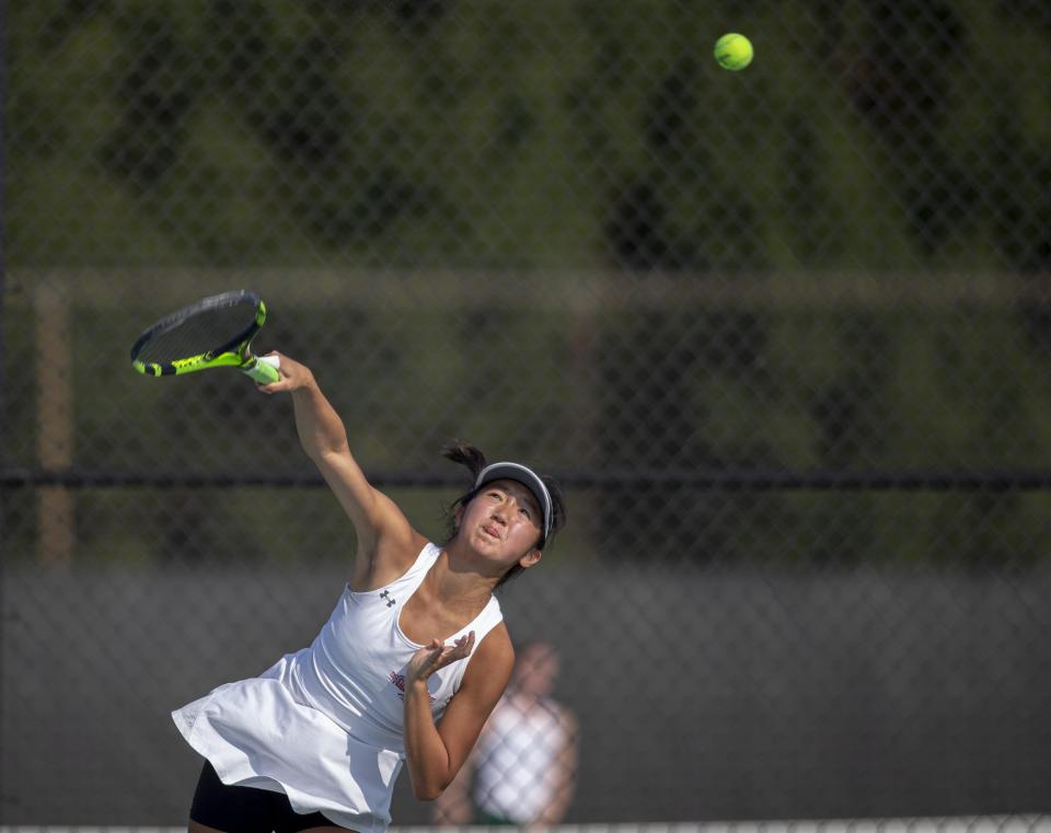 Auburn's Amy Park hits a serve during the No. 1 doubles finals of the 2020 NIC-10 girls tennis tournament at Harlem in Machesney Park.