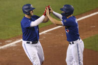 Toronto Blue Jays' Travis Shaw, left celebrates his two-run home run with teammate Randal Grichuk during the fourth inning of a baseball game against the Baltimore Orioles, Friday, Sept. 25, 2020, in Buffalo, N.Y. (AP Photo/Jeffrey T. Barnes)